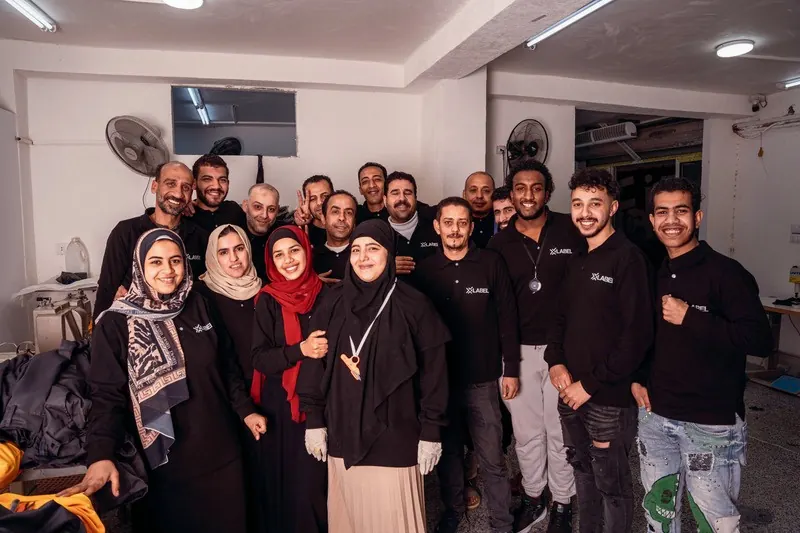 The XLabel production team, men and women in black XLabel tops, on the factory floor