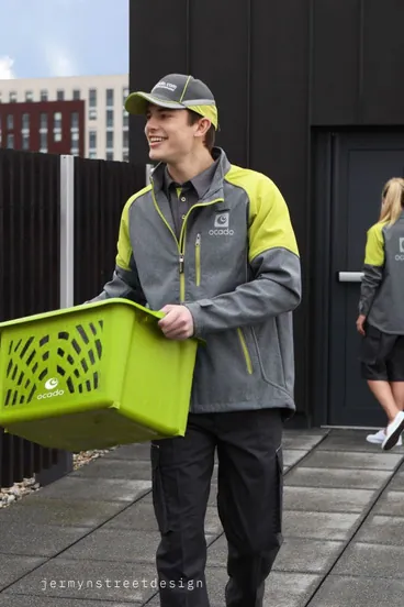 Facility services worker in a grey and lime jacket