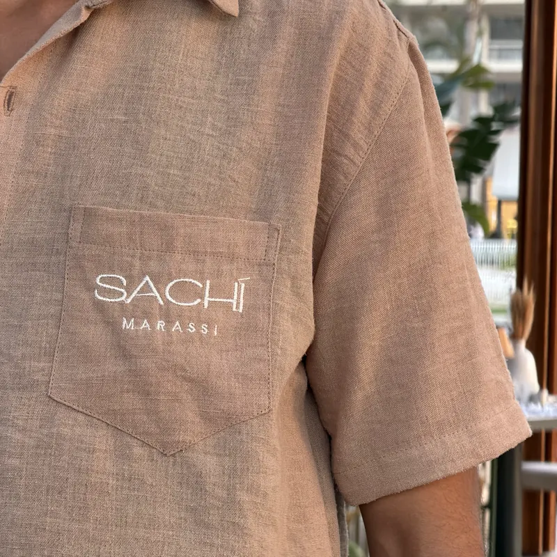 Close-up of the Sachi Marassi logo on a linen shirt pocket
